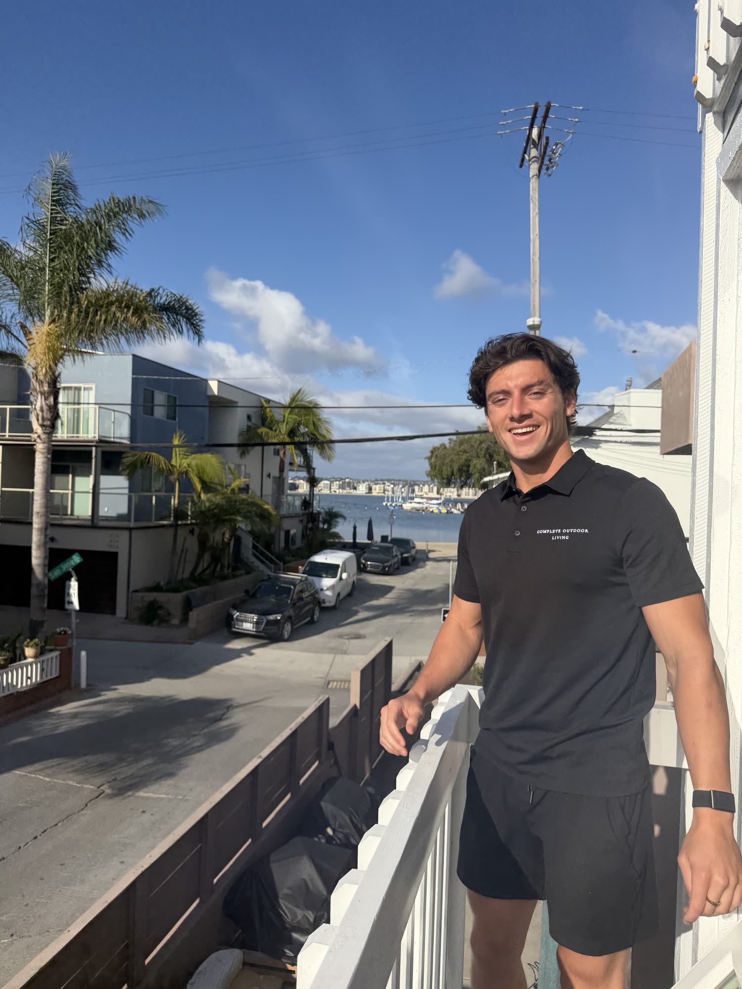 Isaac Reyna of Complete Outdoor Living on a balcony overlooking Mission Bay, San Diego